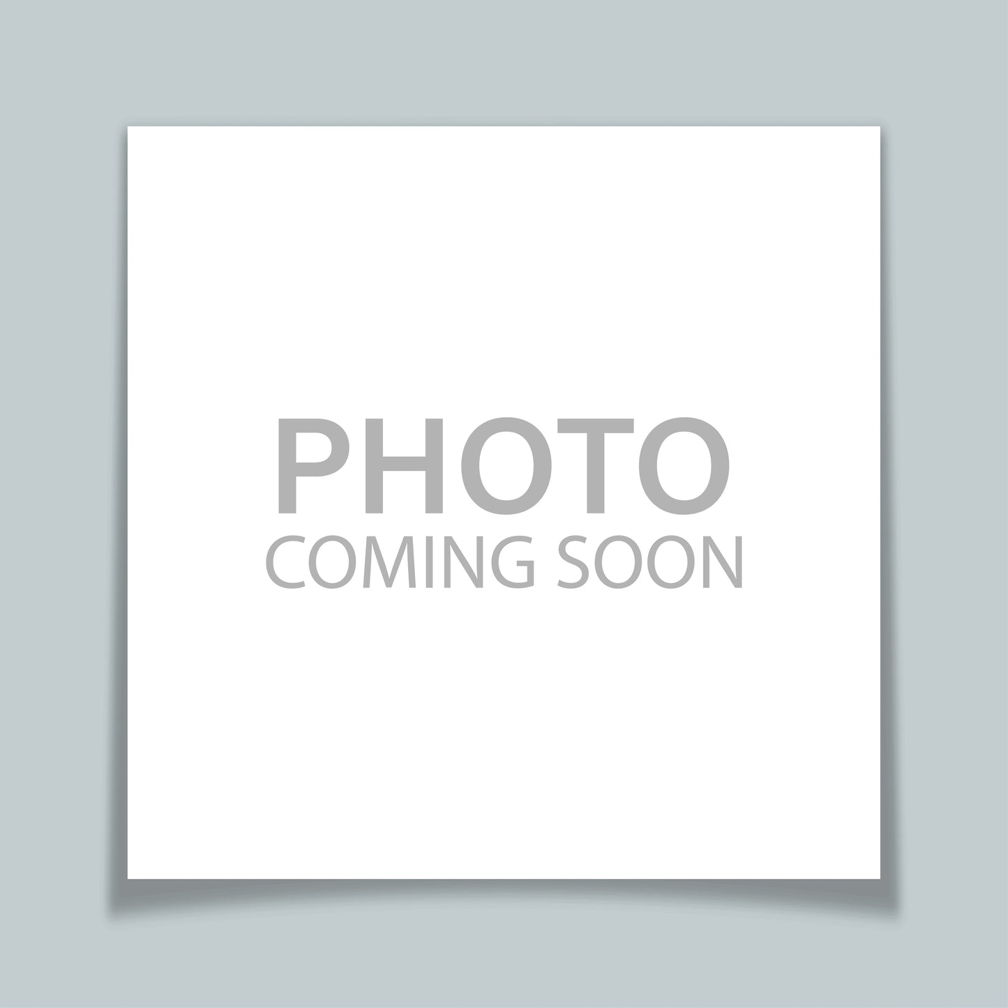 A placeholder image with a white square casting a drop shadow onto a light blue background with text in grey capital letters that says "photo coming soon"